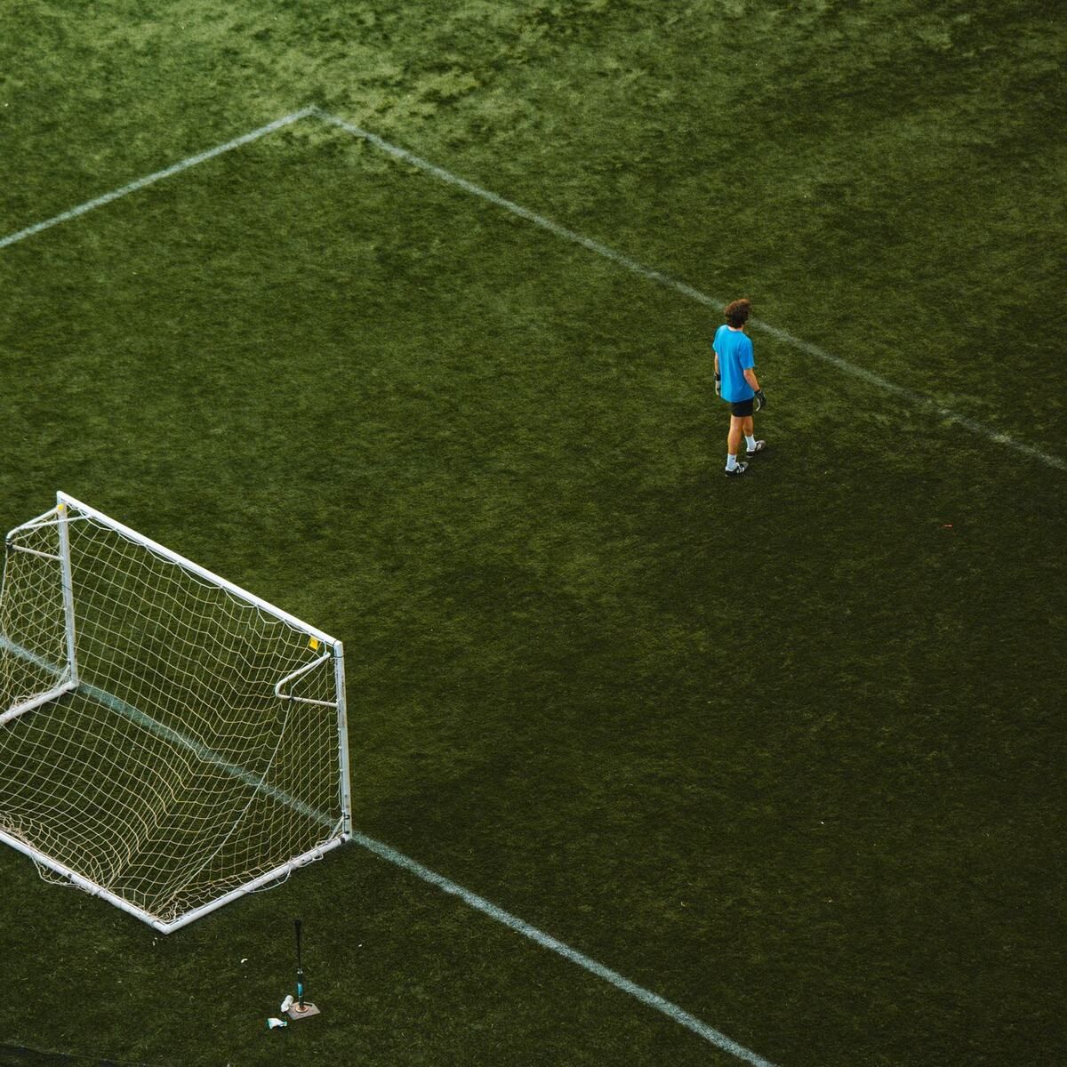 Aerial view of a lone footballer beside the goal