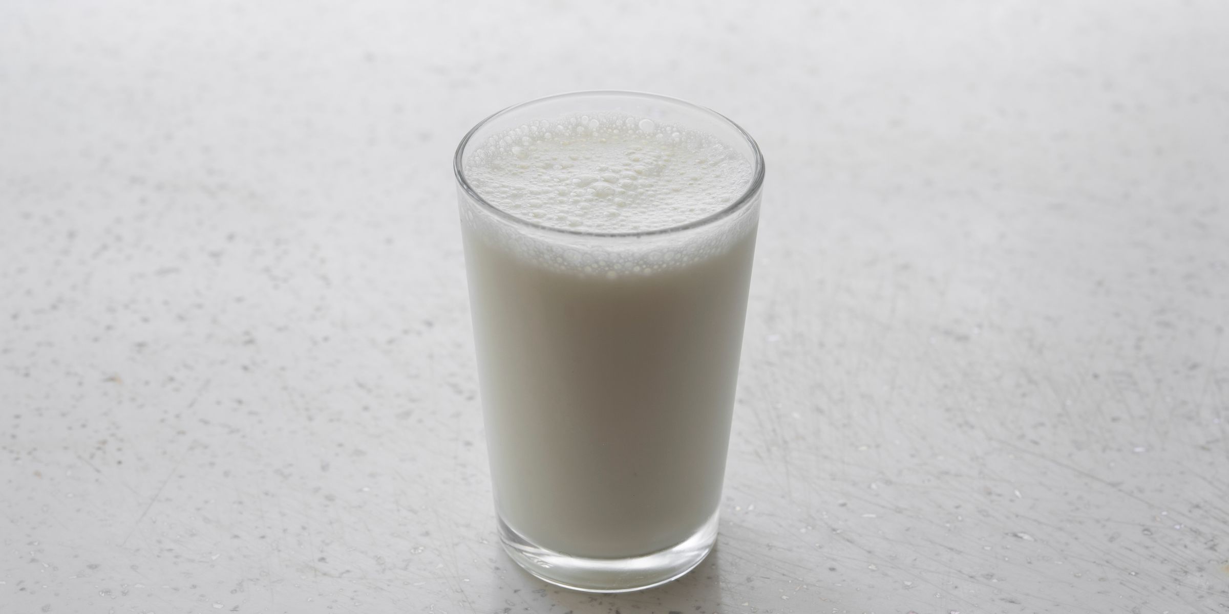 Glass of a white shake on a stone surface